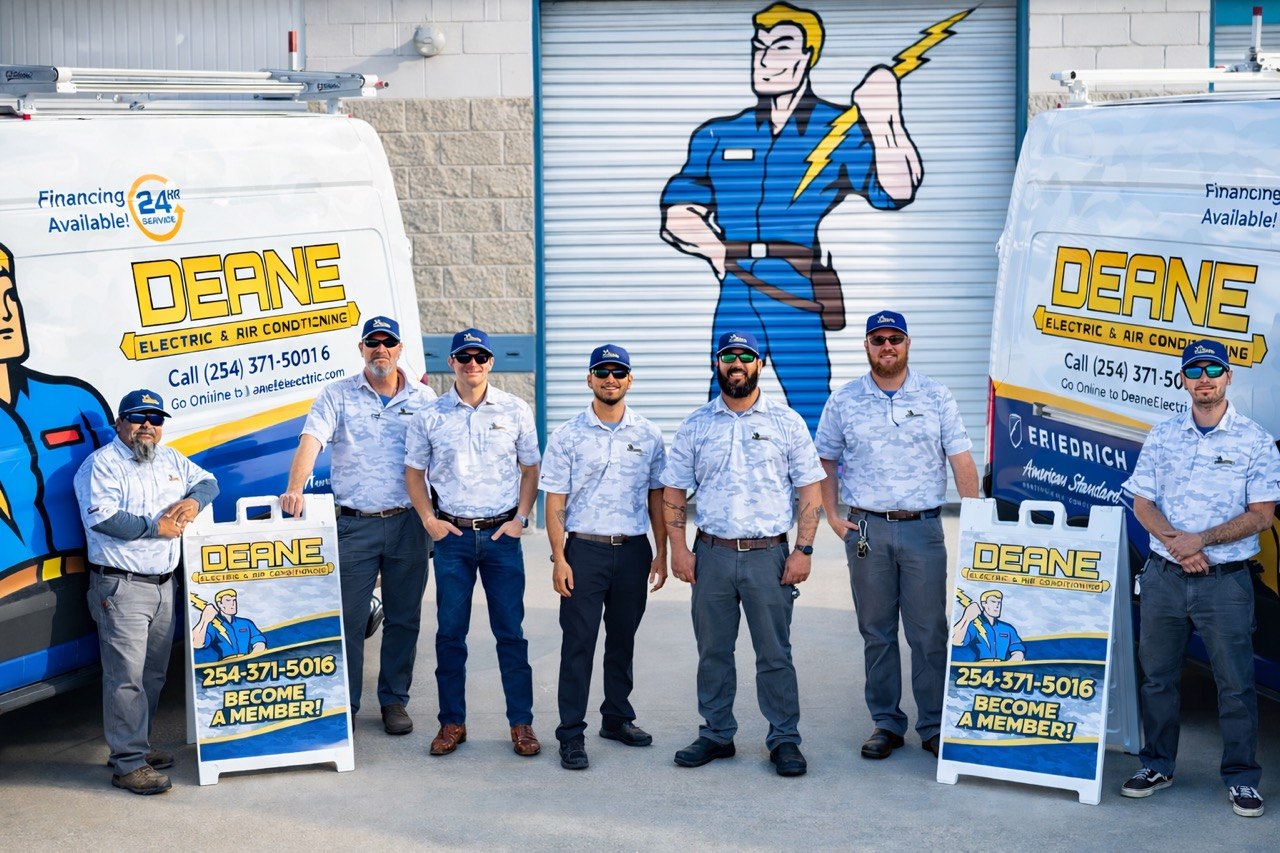 Deane Electric team in front of service trucks